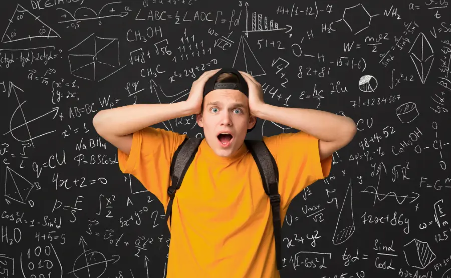 Student looking overwhelmed in front of a chalkboard full of math