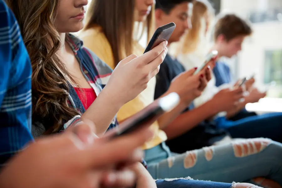 Teenagers texting on their phones