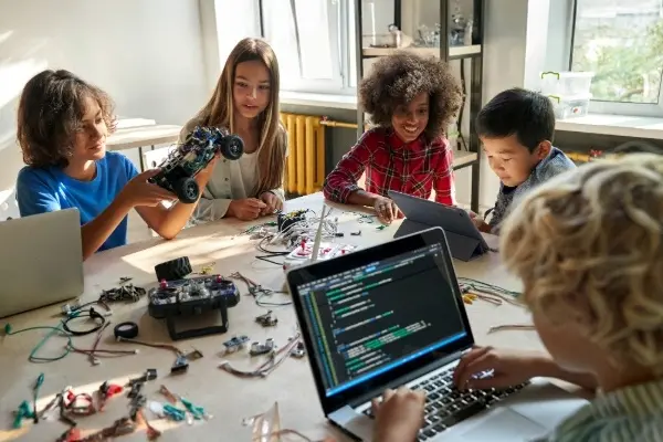Students collaborating with robotics and coding tools